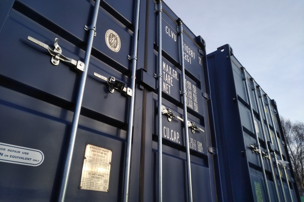 two immaculate blue shipping containers
