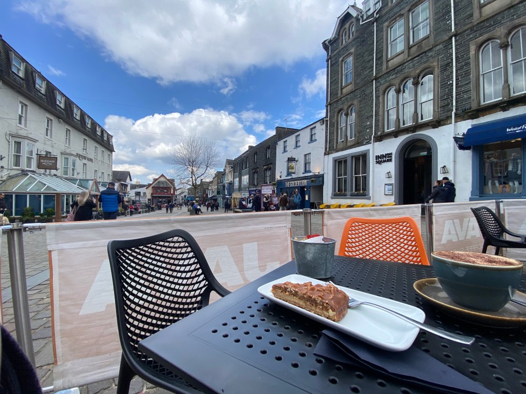 cumbrian town view with a cake and coffee in the foreground