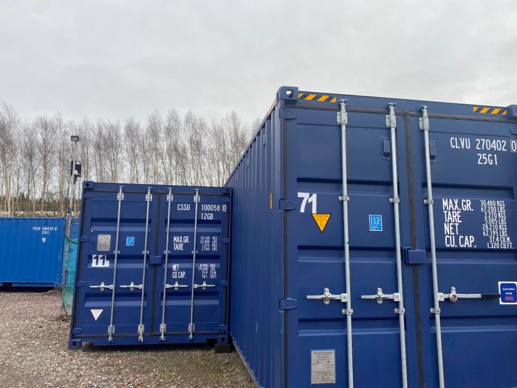 a small shipping container next to a large shipping container