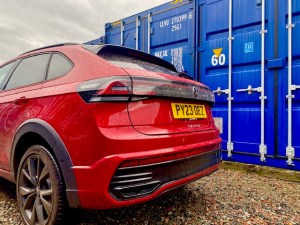 a red car parked beside a container storage unit