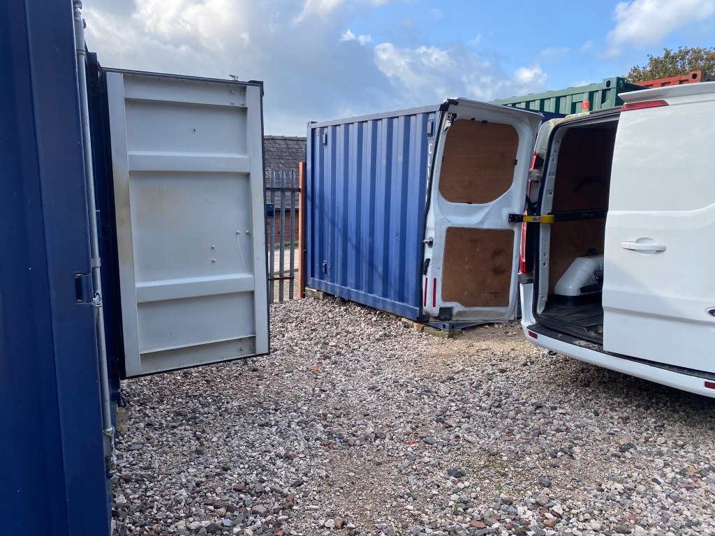 small van delivering goods to a storage unit