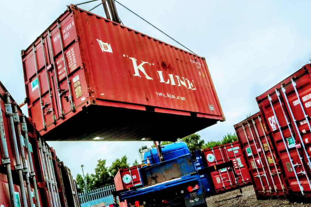 shipping container depot with a crane lifting a shipping container