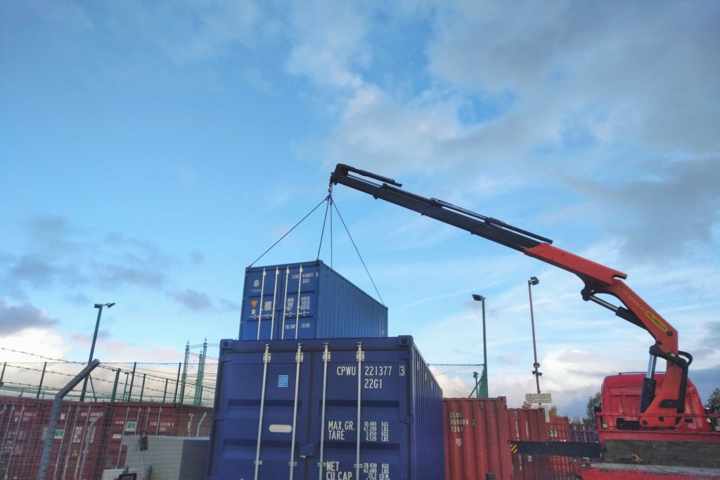 a hiab siting brand new shipping containers used in self storage