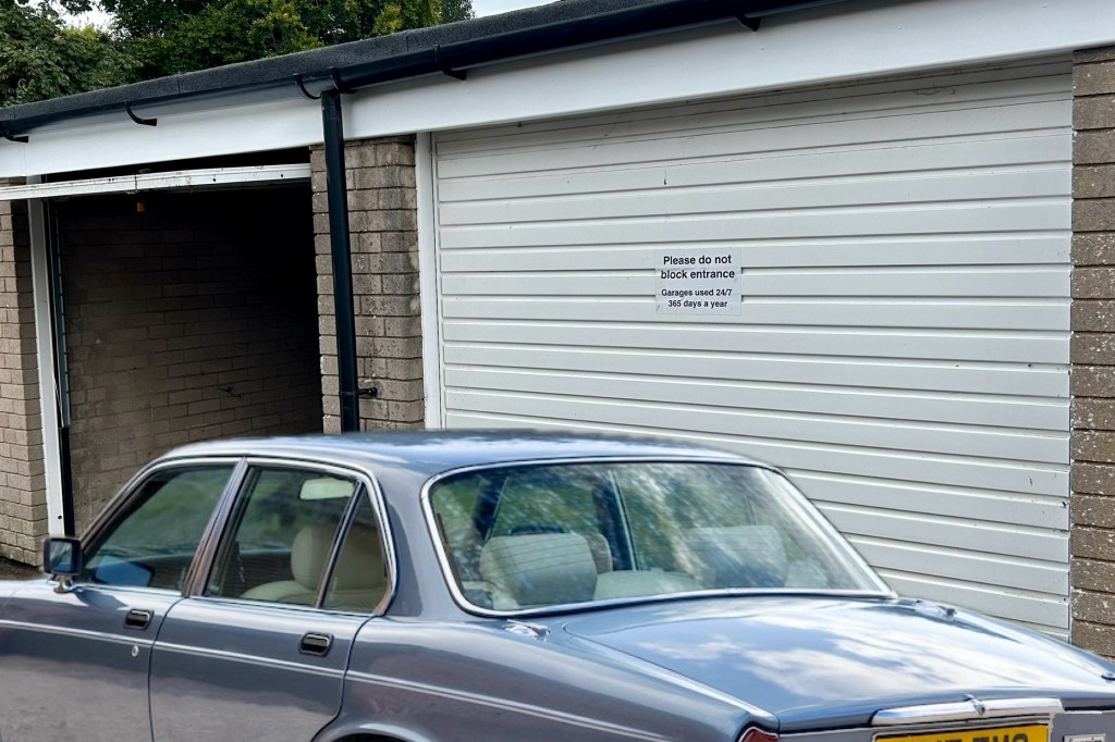 a classic car beside a lock up garage
