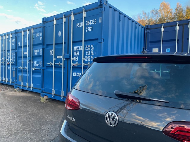 a car parked next to a shipping container