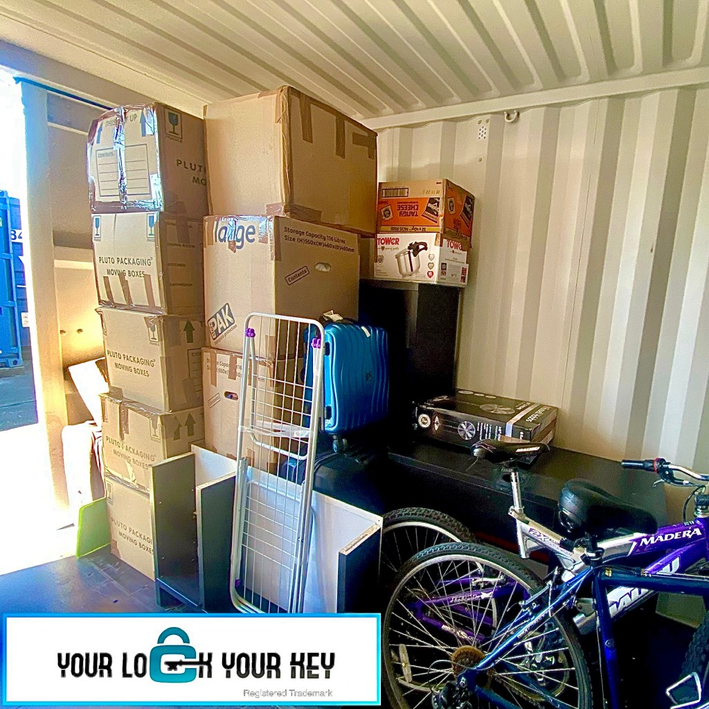The inside of a self storage unit showing personal items including a bike and boxes.