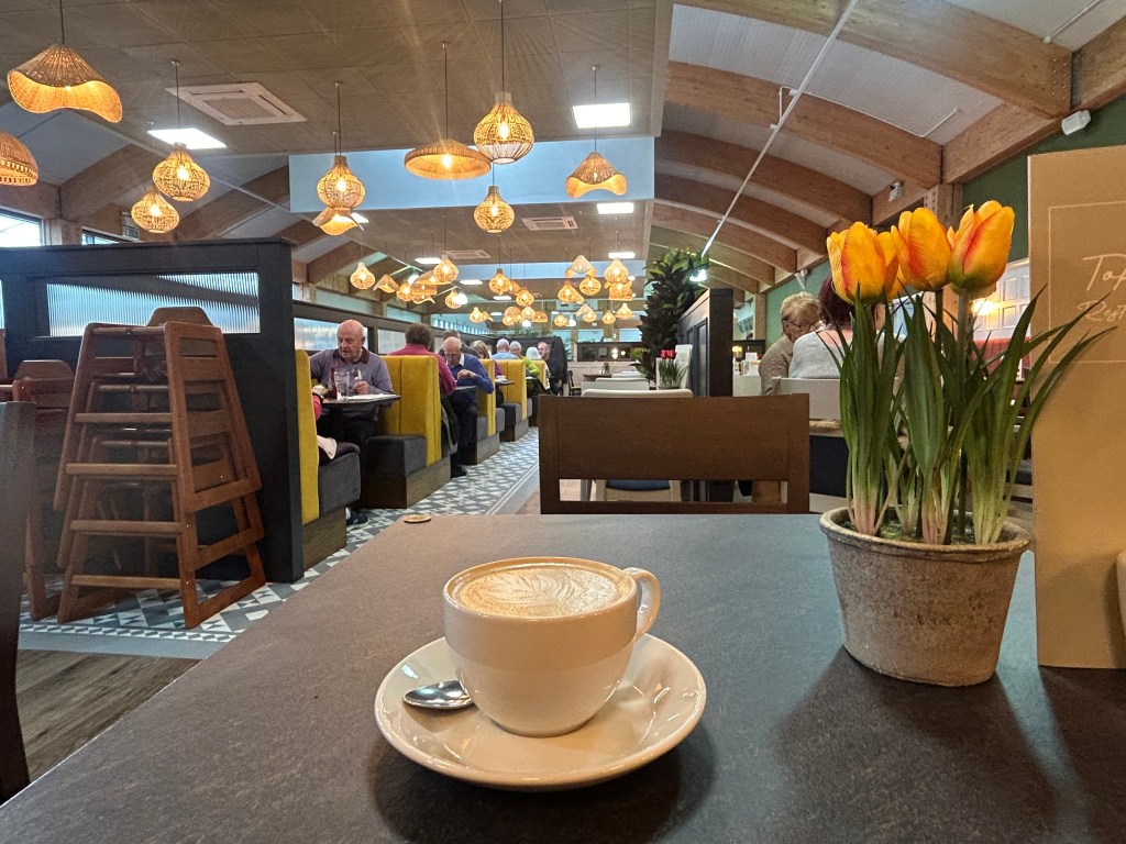 Houghton Hall garden centre Cafe in Carlisle showing a cup of coffee on a table. 