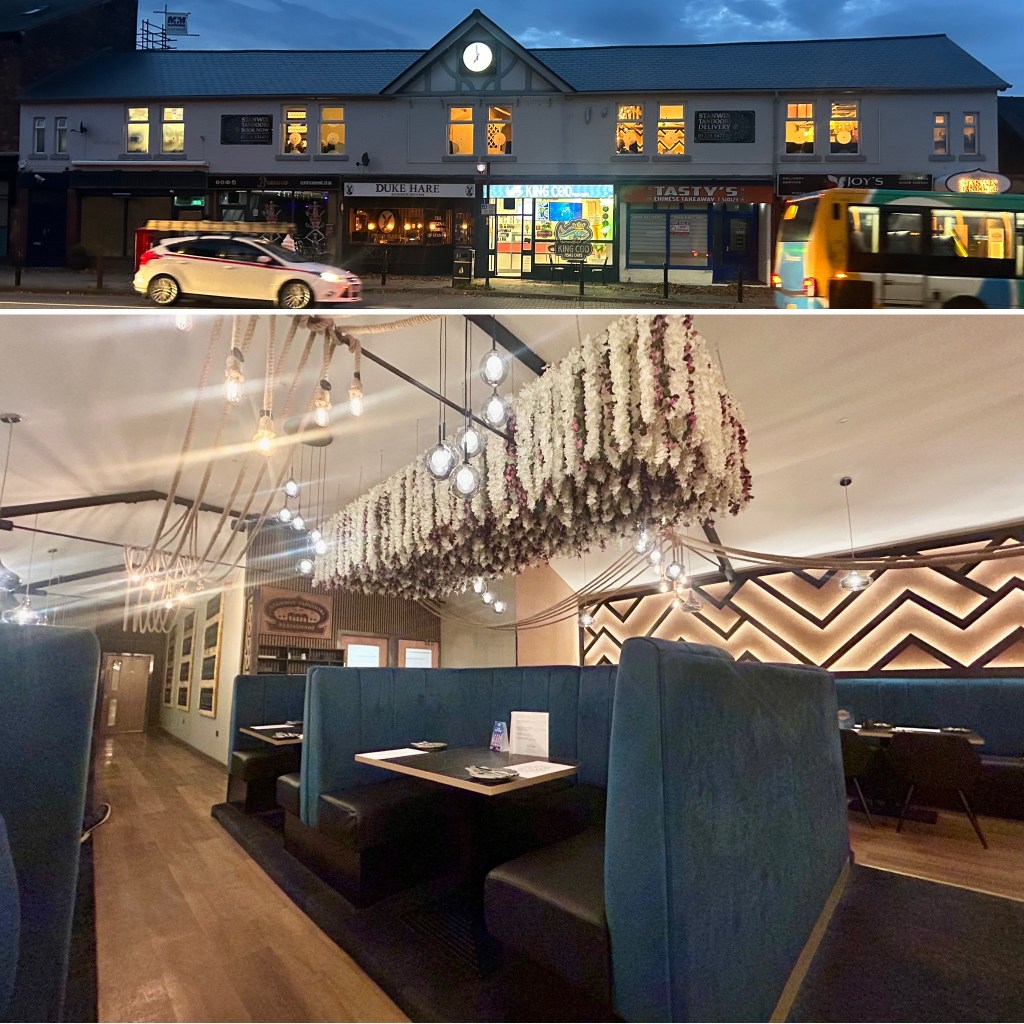 Stanwix Tandoori Restaurant in Carlisle exterior at dusk featuring a clock, brightly lit windows, and various storefronts, including a picture of the interior of the restaurant. 