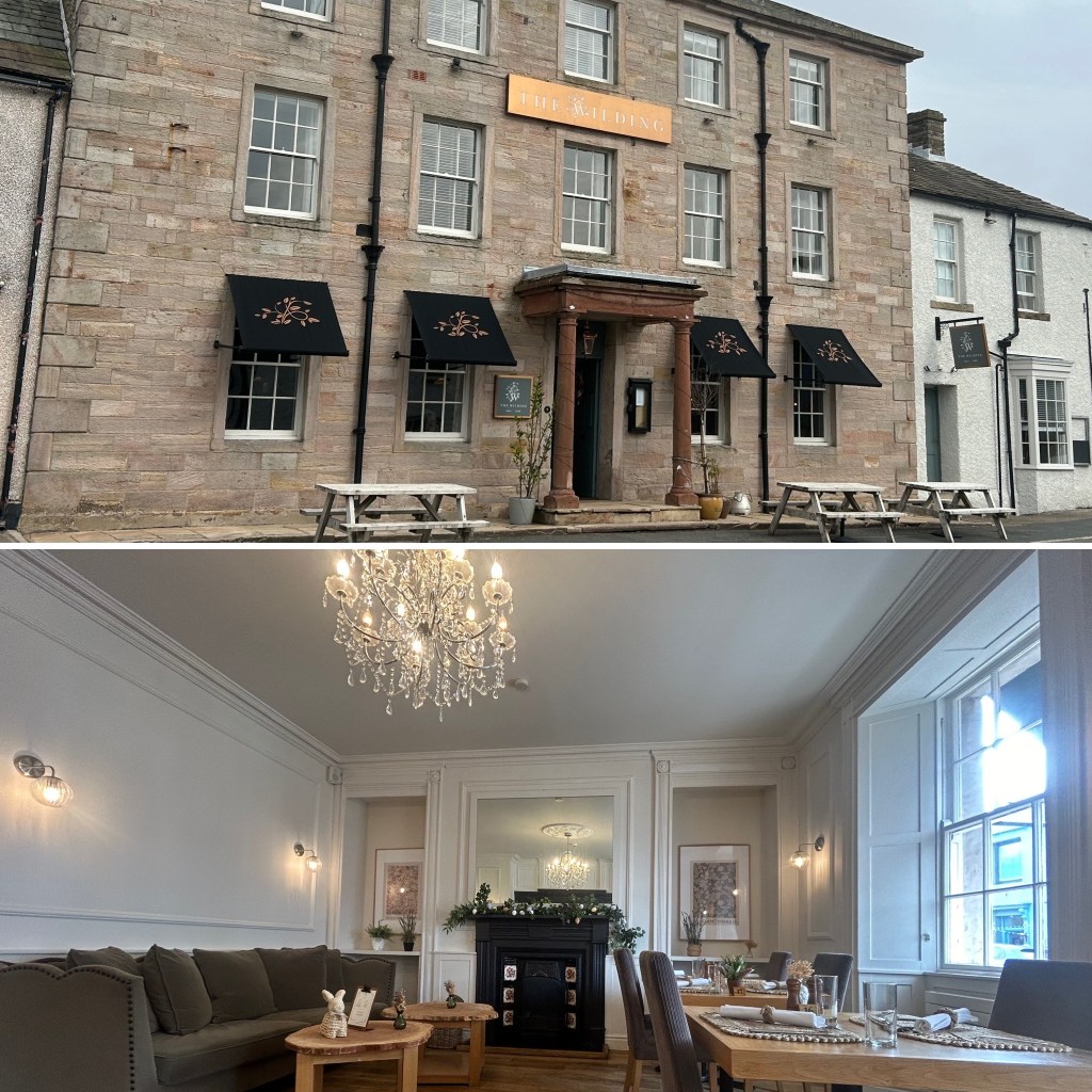Exterior view of a stone building with the sign 'The Wilding' in Brough, Cumbria and black awnings, featuring outdoor seating.