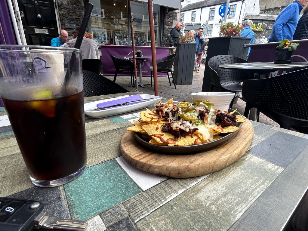 A Pepsi and plate of nachos on a table at The Magic Roundabout Café in Windemere.